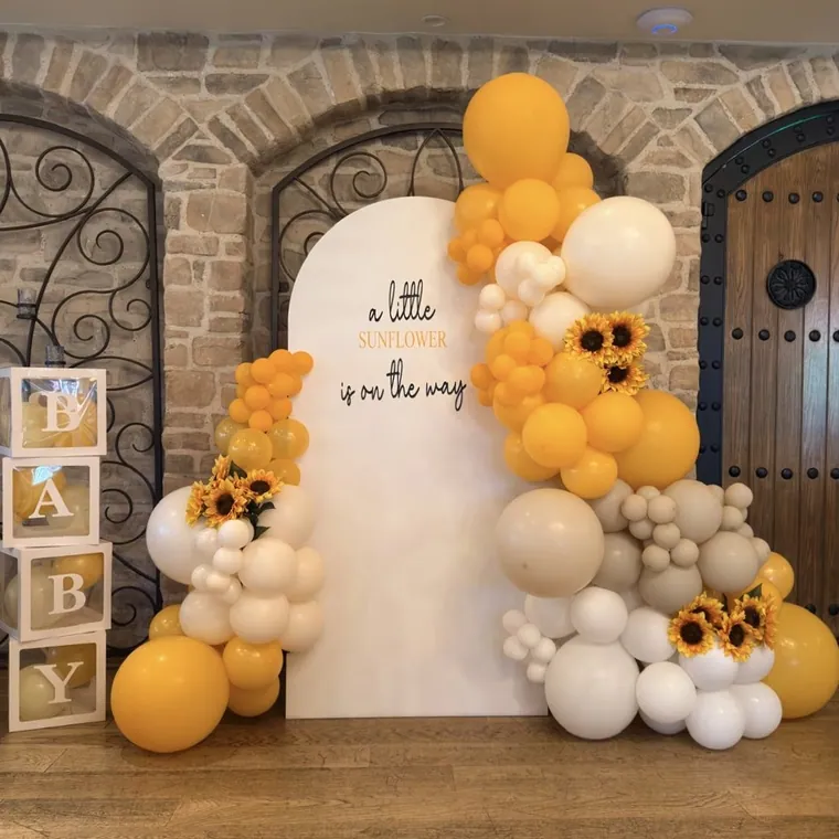 Yellow and cream sunflower balloon backdrop with BABY letter blocks.
