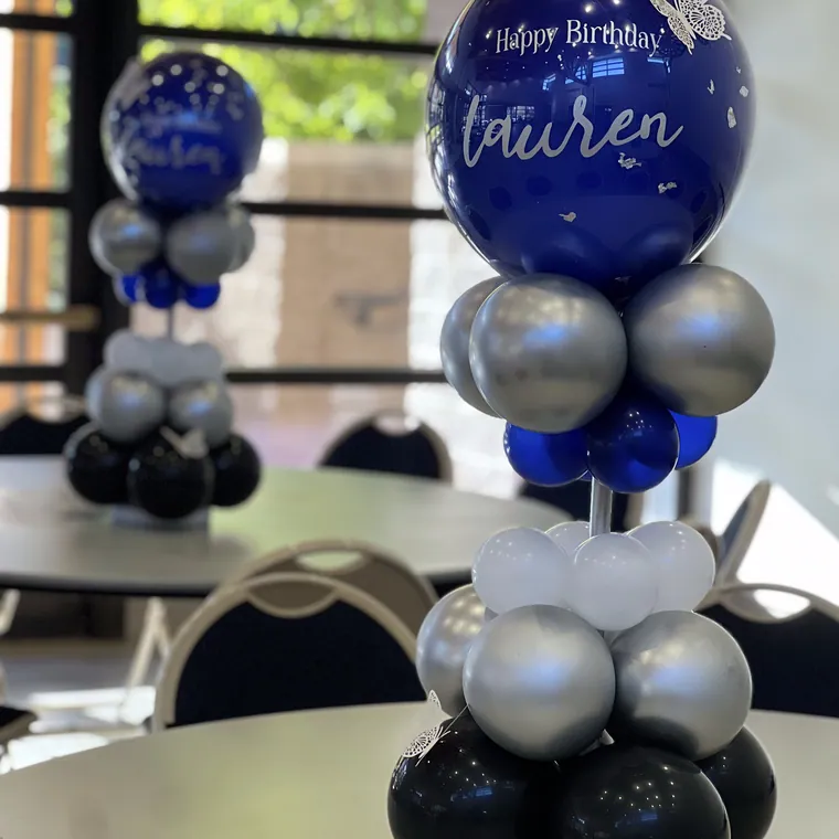 Navy and silver balloon centerpiece on a round table.