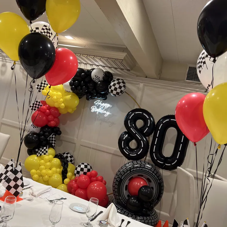 Black, red and yellow balloon table styling with chequered accents.