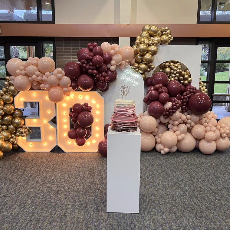 Light-up marquee 80 with burgundy, blush and gold balloon clusters.