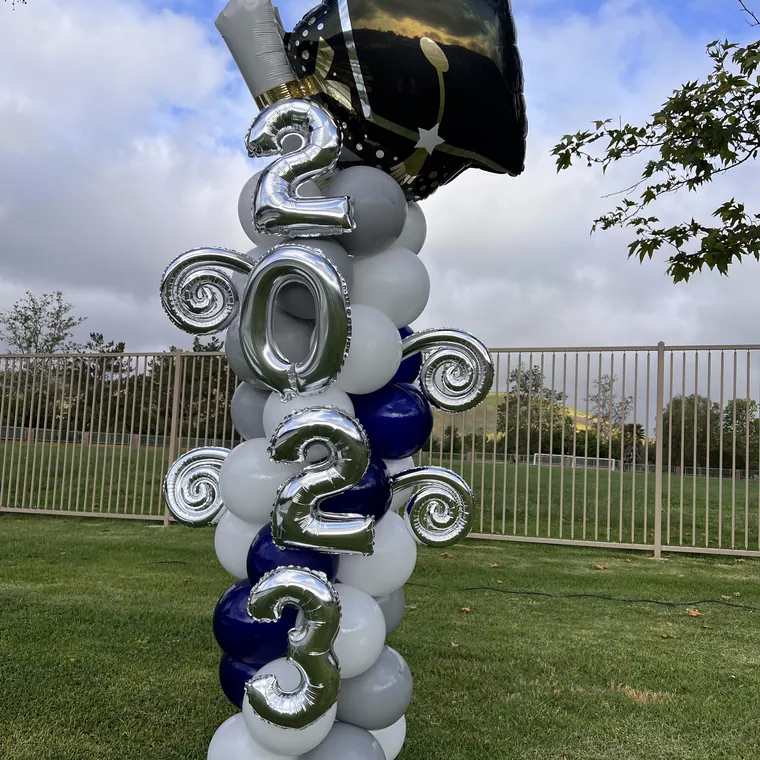 Silver foil graduation year numbers with a navy and silver balloon column.