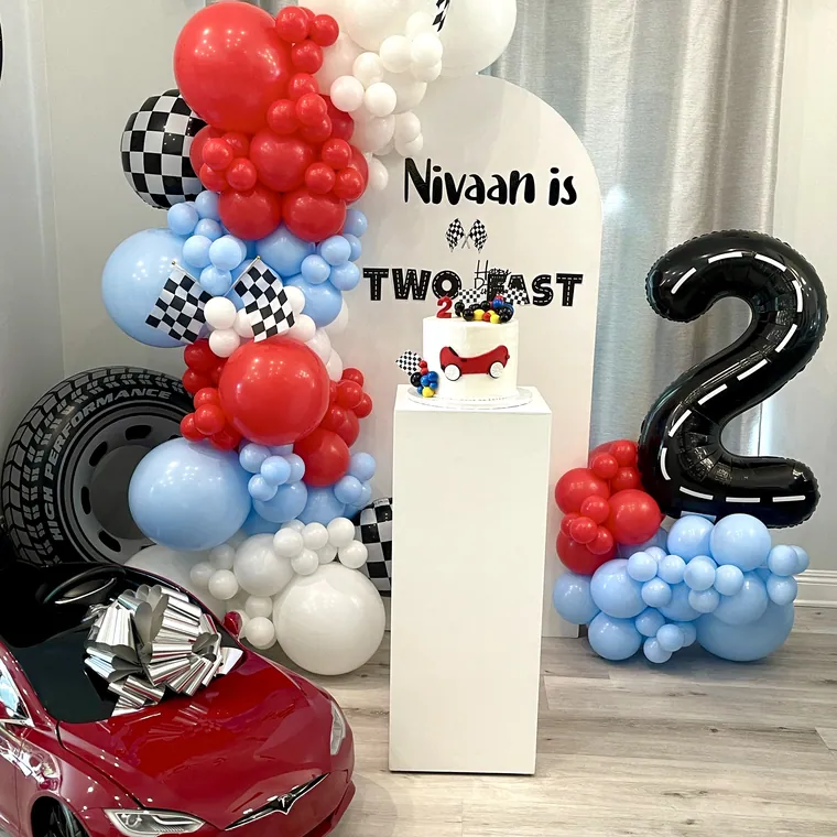 Race car themed balloon setup in red, blue and chequered black and white.