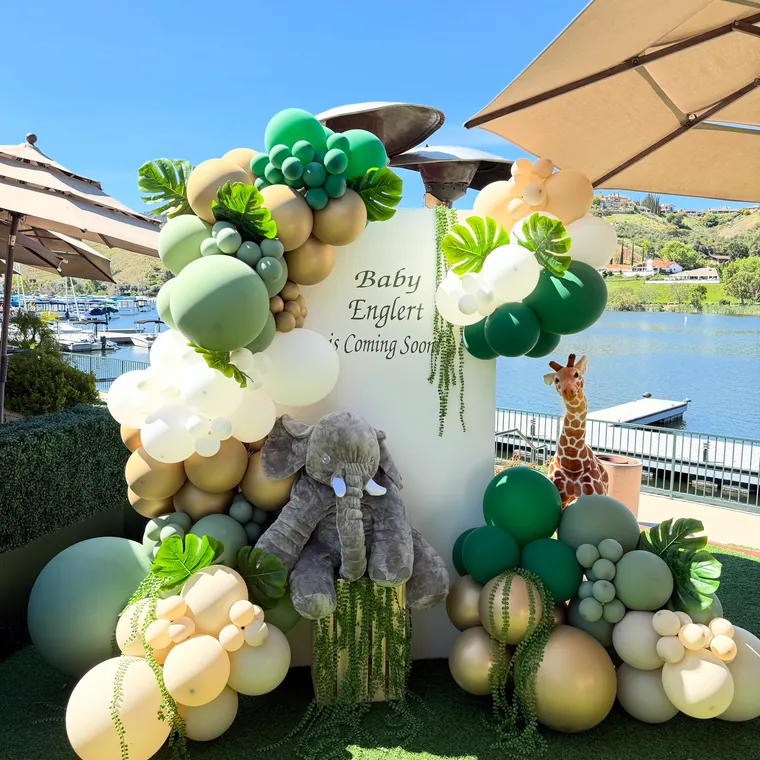 Safari themed balloon installation in greens and creams with animal props.
