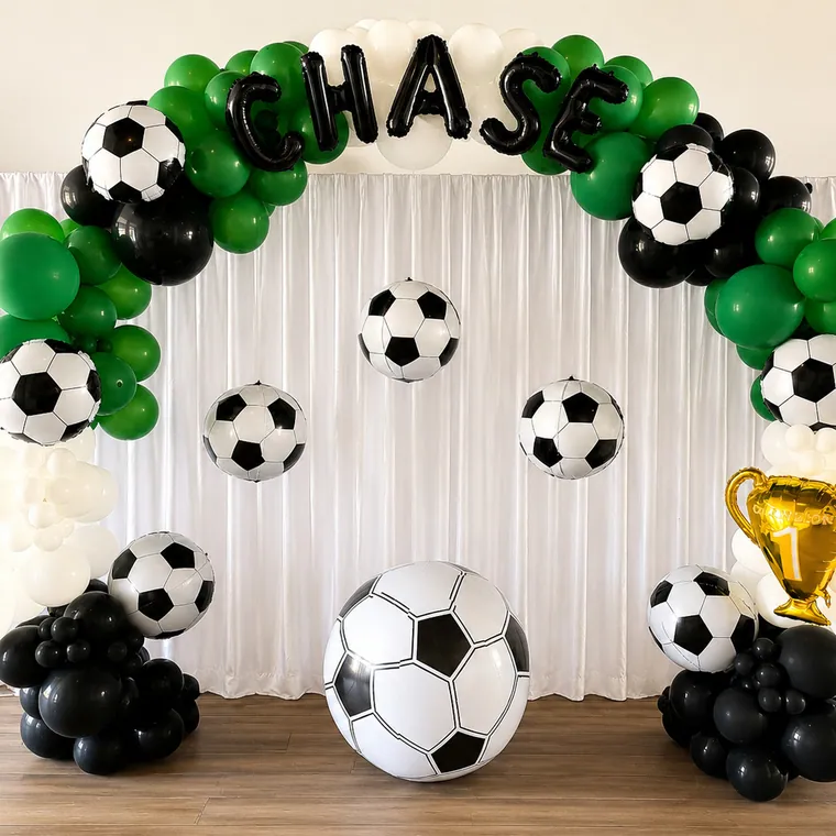 Soccer themed balloon backdrop in green, black and white with foil footballs.