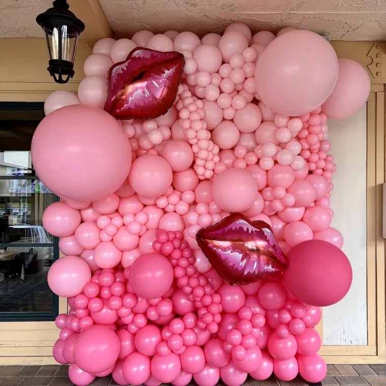 Dense pink balloon mosaic wall with foil lips worked into it.
