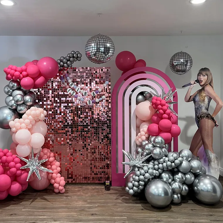 Hot pink sequin wall with silver and pink balloon clusters.