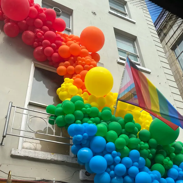 Rainbow balloon installation running up the side of a building.