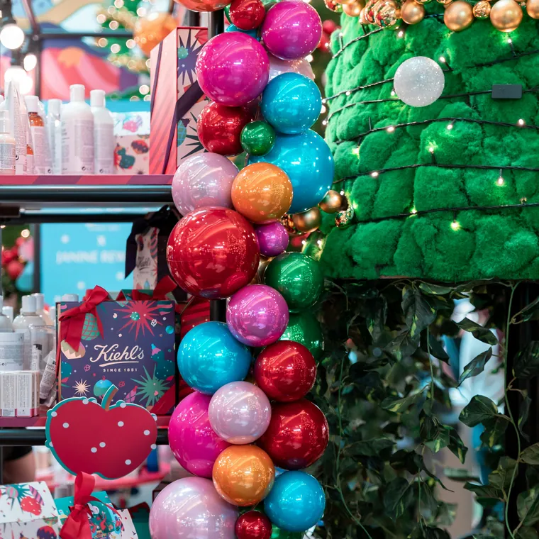 Colourful balloon display built into retail shelving.