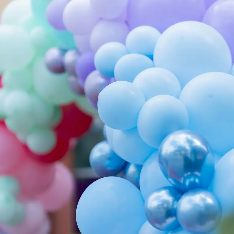 Blue, lavender and chrome balloon garland photographed close up.